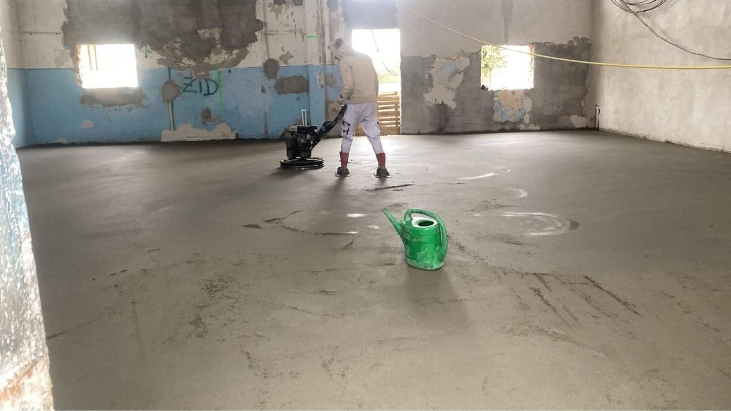 muncitor in construcii care finiseaza o sapa elicopterizata cu ajutorul echipamentului special